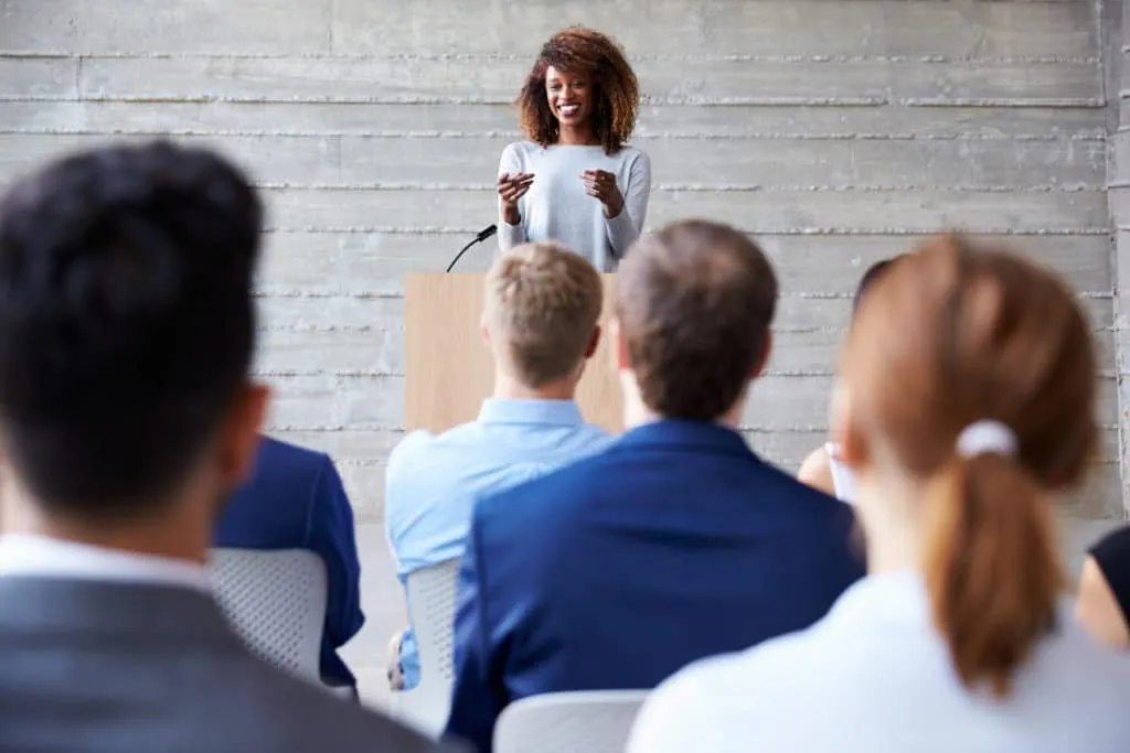 Woman speaking to a crown of people